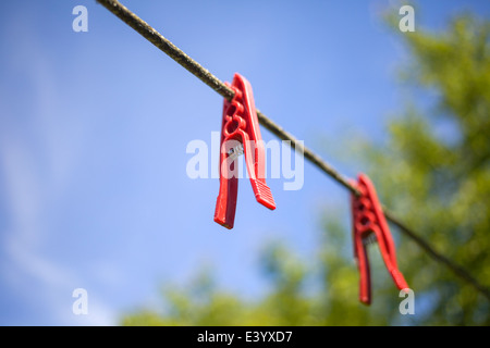 Roten Wäscheklammern vor blauem Himmel Stockfoto