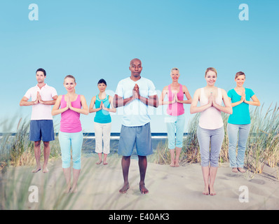 Gruppe von Menschen, die Yoga am Strand Stockfoto