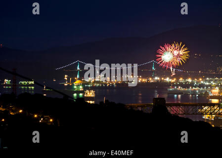 Vancouver, BC, Kanada. Juli 2014. Feuerwerke aus North Vancouver erhellen die Luft durch die Lion's Gate Bridge und den Burrard Inlet mit Farbe. Diese Veranstaltung war eine von mehreren Feierlichkeiten zum Canada Day in Greater Vancouver, die Kanadas 147. Geburtstag feierten. Credit: Maria Janicki/Alamy Stockfoto