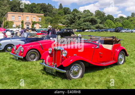 East Devon, England. Eine Fete und Gartenfest an ein Landhaus mit Oldtimer, klassische Fahrzeuge in den Vordergrund und die Zuschauer. Stockfoto