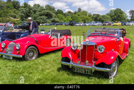 East Devon, England. Eine Fete und Gartenfest an ein Landhaus mit Oldtimer, klassische Fahrzeuge in den Vordergrund und die Zuschauer. Stockfoto