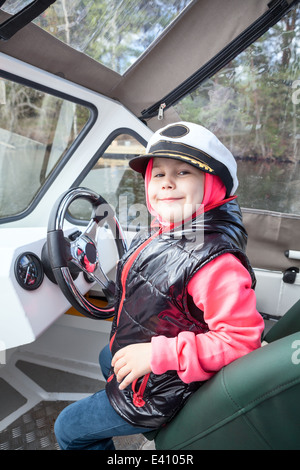 Glücklich lächelnd kaukasische Mädchen fahren Motorboot als Kapitän an deck Stockfoto