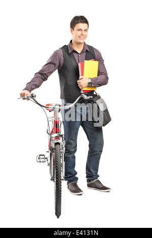 In voller Länge Portrait eines männlichen Studenten halten Bücher und ein Fahrrad schieben Stockfoto