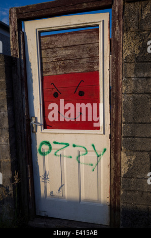 Als ich durch eine Gasse ging, entdeckte ich diese Tür und den Rahmen, der als Tor zu einem Gartenbereich diente. Ein paar Graffiti haben es schön gemacht. Stockfoto