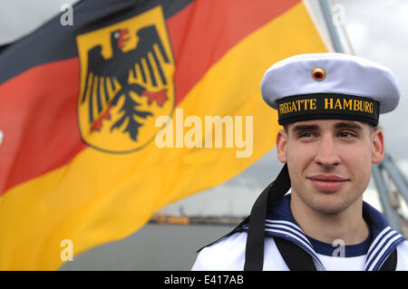 Wilhelmshaven, Deutschland. 2. Juli 2014. Lanze-Obergefreites Kenneth Flocke aus Hamburg steht vor einer deutschen Flagge an Bord der Fregatte "Hamburg" auf dem Marinestützpunkt Wilhelmshaven, Deutschland, 2. Juli 2014. Die Fregatte nahm an verschiedenen internationalen Manöver seit 11. Februar 2014. Foto: CARMEN JASPERSEN/Dpa/Alamy Live News Stockfoto