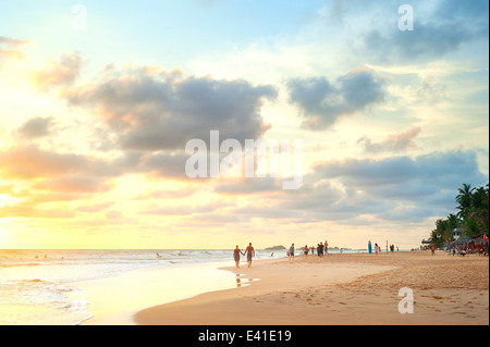 Menschen zu Fuß an den Strand von Sri Lanka bei Sonnenuntergang Stockfoto