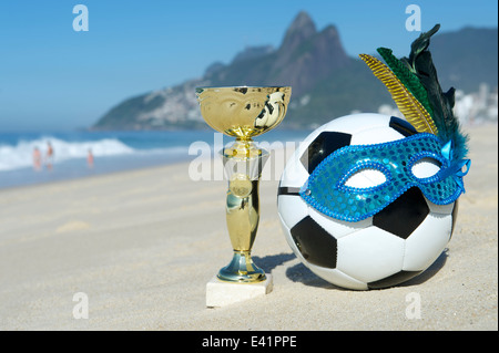 Brasilien Fussball Champion Trophy mit Fußball Karneval Maske auf Ipanema Strand Rio de Janeiro Brasilien Stockfoto