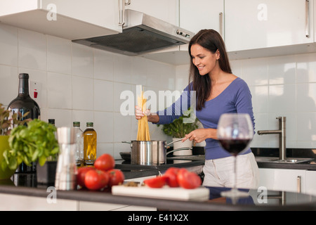 Junge Frau, die kochen Spaghetti in Küche Stockfoto