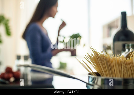 Verschwommenes Bild der jungen Frau, die Zubereitung von Speisen in der Küche Stockfoto