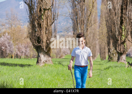 Zwölf Jahre alter Junge, ein Spaziergang mit Gehstock Stockfoto