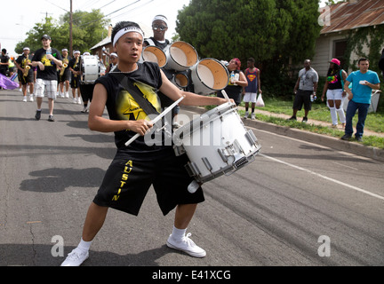 Asiatischen männlichen Teenager spielt die Trommel während einer Juneteenth-Parade in Austin, Texas Stockfoto
