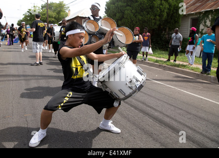 Asiatischen männlichen Teenager spielt die Trommel während einer Juneteenth-Parade in Austin, Texas Stockfoto