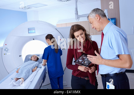 Arzt und Mutter Blick auf Scan, Mädchen ins CT-scanner Stockfoto