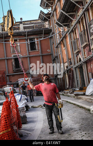 L ' Aquila, Italien. 2. Juli 2014. Ein Mann bei der Arbeit für den Wiederaufbau der beschädigten Gebäude nach dem Beben von 6. April 2009 in l ' Aquila, Italien, am 2. Juli 2014. © Manuel Romano/NurPhoto/ZUMA Draht Stockfoto