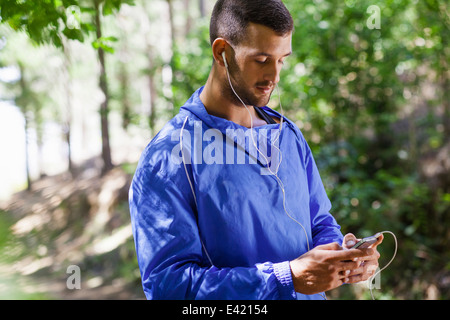 Männliche Jogger mit mp3 im Wald Stockfoto