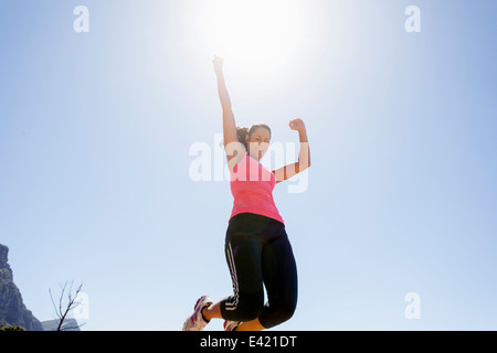 Weibliche Jogger springen in der Luft Stockfoto