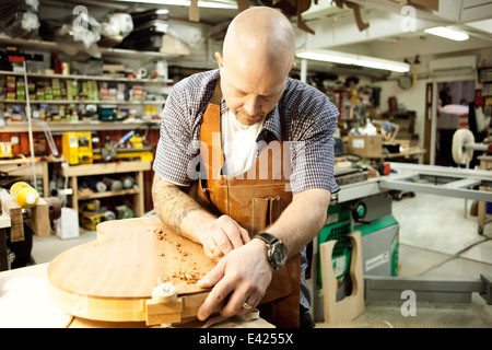 Gitarrenbauer aus Holz Gitarre Form in der Werkstatt messen Stockfoto