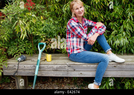 Porträt von Reife Frau eine Pause auf Gartenbank Stockfoto