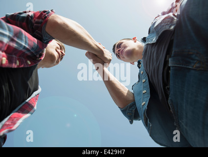 Blick von unten auf junge Männer, Hände schütteln Stockfoto