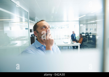 Mann denkt, Menschen im Hintergrund Stockfoto