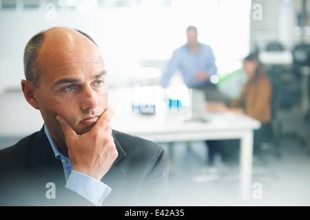 Mann denkt, Menschen im Hintergrund Stockfoto