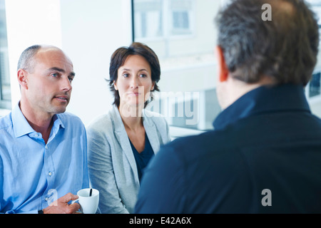 Geschäftsleute, die im Chat im Büro Stockfoto