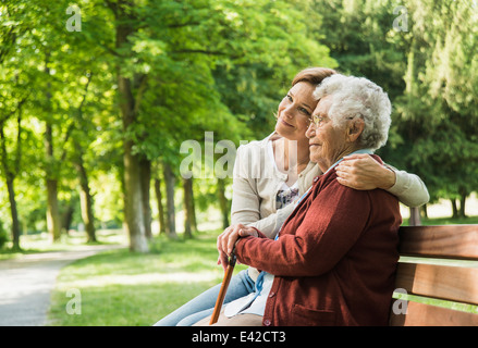 Ältere Frau sitzen auf der Parkbank mit Enkelin Stockfoto