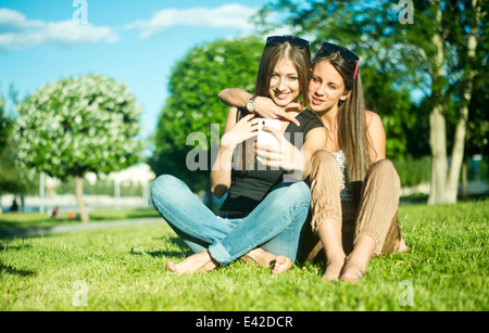 Zwei junge Freundinnen unter Selbstportrait auf Smartphone im park Stockfoto