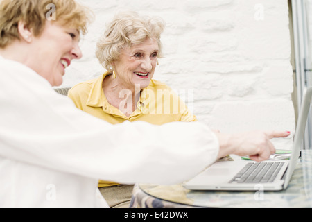 Ältere Frau und Tochter Blick auf laptop Stockfoto