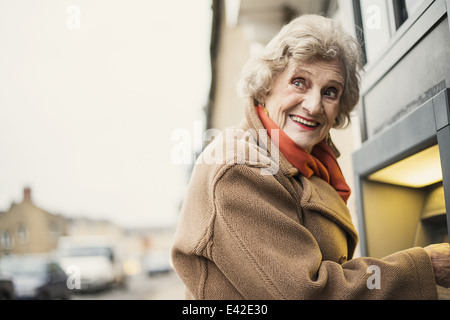 Ältere Frau mit Geldautomat Stockfoto