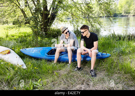 Zwei junge Männer sitzen auf einem Kanu Stockfoto