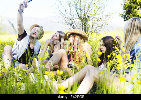 Gruppe von Freunden sitzen im Rasen selbst fotografieren Stockfoto
