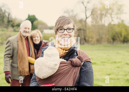 Mutter mit Baby Sohn, Großeltern im Hintergrund Stockfoto