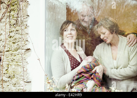 Mutter mit Kind und Großeltern Blick aus Fenster Stockfoto