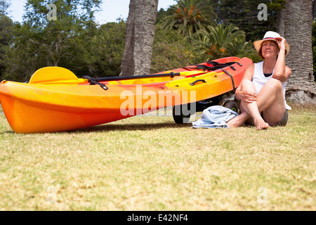 Ältere Frau Schneidersitz sitzen am Strand Stockfoto