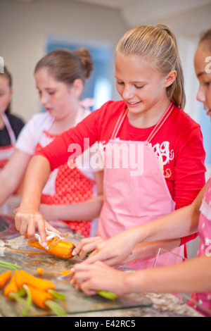 Mädchen im Teenageralter Vorbereitung Karotten in Küche Stockfoto