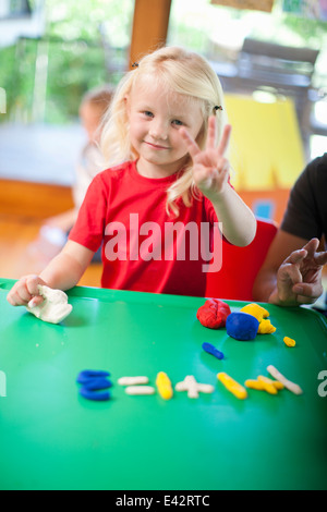 Porträt eines Mädchens zählen mit Fingern im Kindergarten Stockfoto