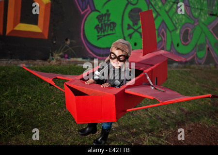 Jungen tragen fliegende Schutzbrille läuft in Spielzeugflugzeug im Park in der Nacht Stockfoto