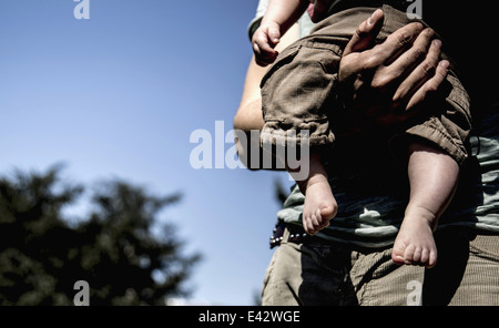 Nahaufnahme der junge Mann trägt Baby Sohn beschnitten Stockfoto