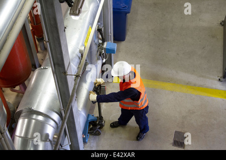 Erhöhte Ansicht des Technikers mit Palette Trolley im Kraftwerk Stockfoto