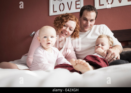 Porträt von Mitte erwachsenes paar mit Sohn und Baby Tochter auf Bett Stockfoto