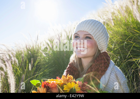 Porträt der jungen Frau mit Blumenstrauß lange Gras Stockfoto