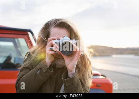 Mitte Erwachsene Frau fotografieren mit SLR in küstennahen Parkplatz Stockfoto