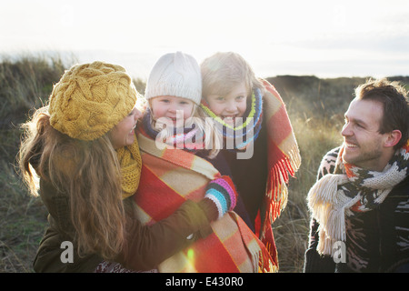 Mitte erwachsenes paar in Sanddünen mit ihren Sohn und Tochter in Decke gehüllt Stockfoto