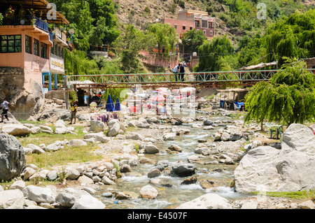 Kunststoff Terrasse Tische, Stühle und Sonnenschirme in den Restaurants am Ufer des Flusses Ourika, Ourika Valley, Atlas, Marokko Stockfoto