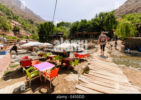 Kunststoff Terrasse Tische, Stühle und Sonnenschirme in den Restaurants am Ufer des Flusses Ourika, Ourika Valley, Atlas, Marokko Stockfoto