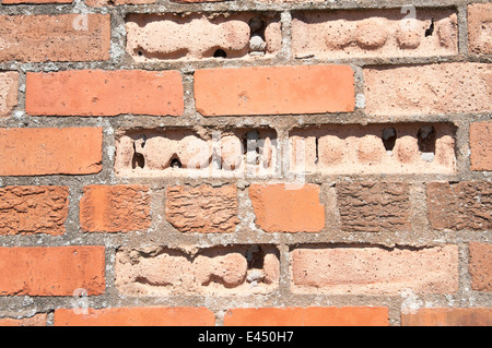 Stark verwitterte und erodierte Ziegel in einer Wand. Stockfoto