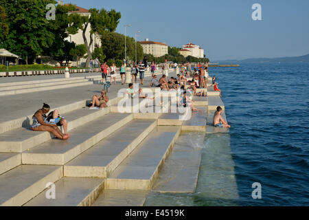 Besucher sonnen sich in der Abendsonne auf die Meeresorgel vom Architekten Nikola Bašić, Zadar, Dalmatien, Kroatien Stockfoto