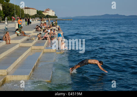 Besucher sonnen sich in der Abendsonne auf die Meeresorgel vom Architekten Nikola Bašić, Zadar, Dalmatien, Kroatien Stockfoto