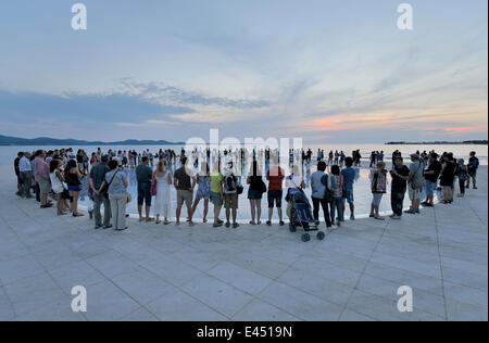 Menschen am Denkmal für die Sonne, Pozdrav Suncu, Architekt von Nikole Bašića bei Dämmerung, Zadar, Dalmatien, Kroatien Stockfoto